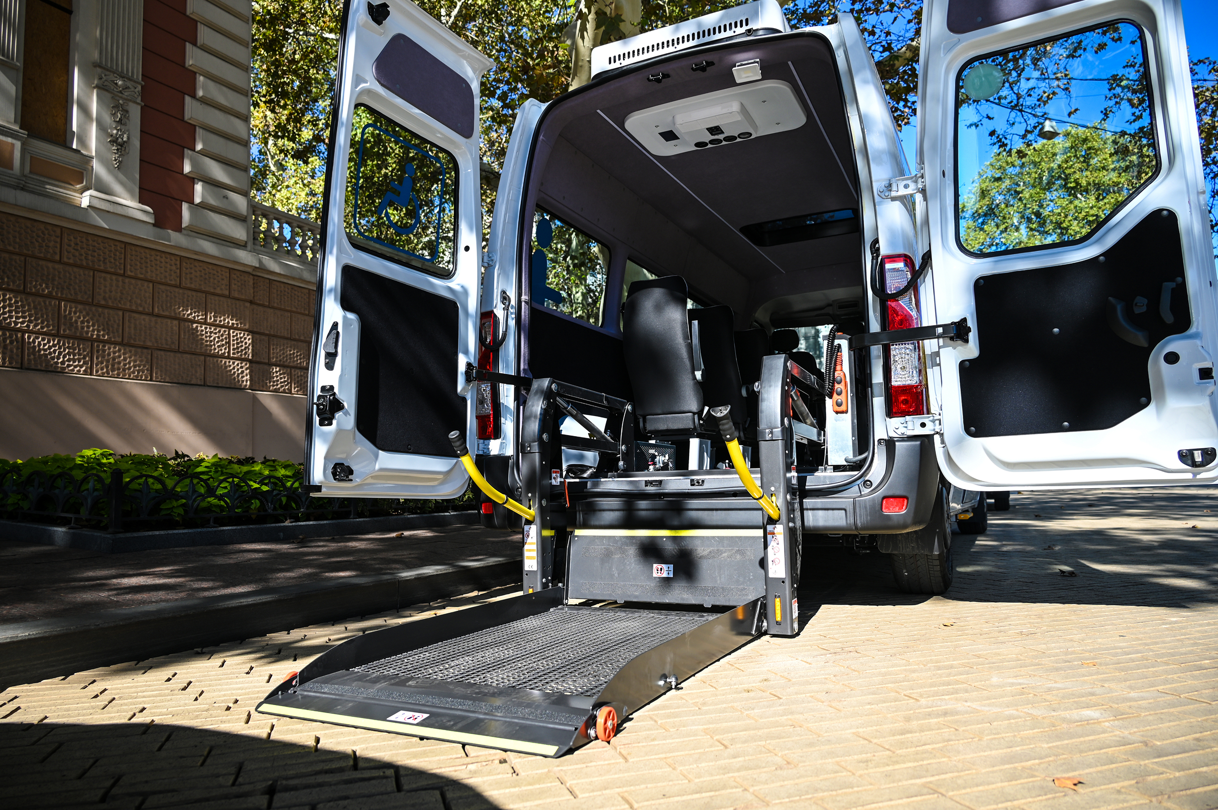 Professional medical transport van with rear wheelchair ramp ready for boarding